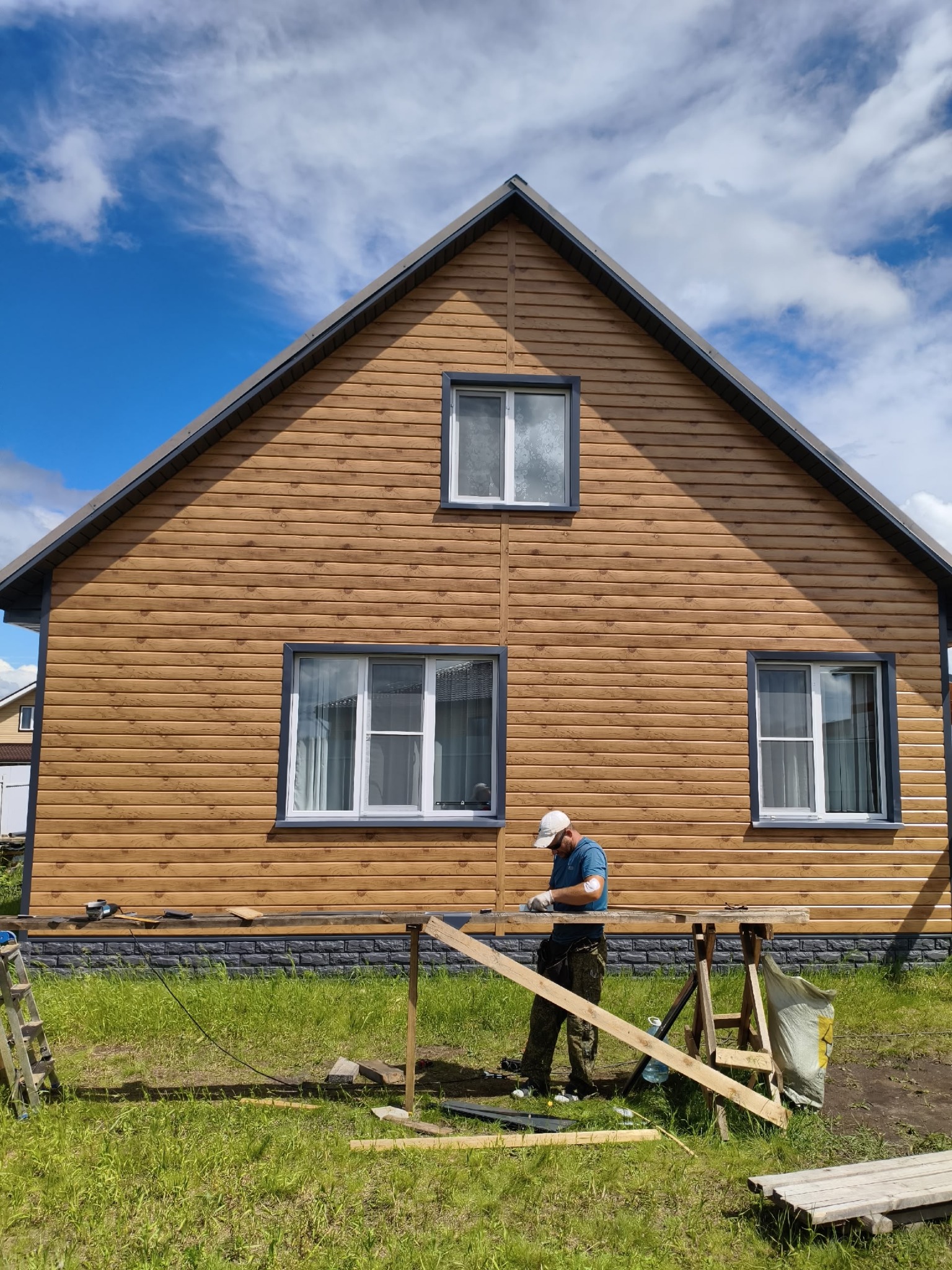 Деревянный дом с графитовой кровлей и крыльцом